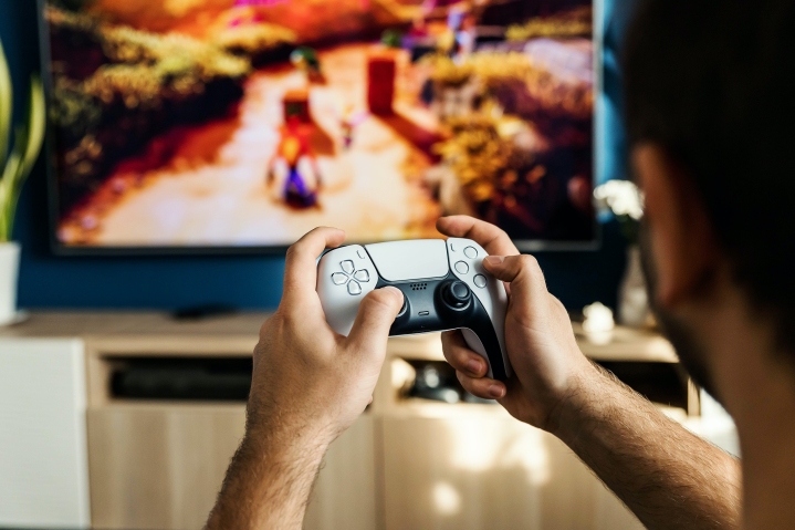 Una persona juega a Crash Bandicoot con un controlador PS5 DualSense.