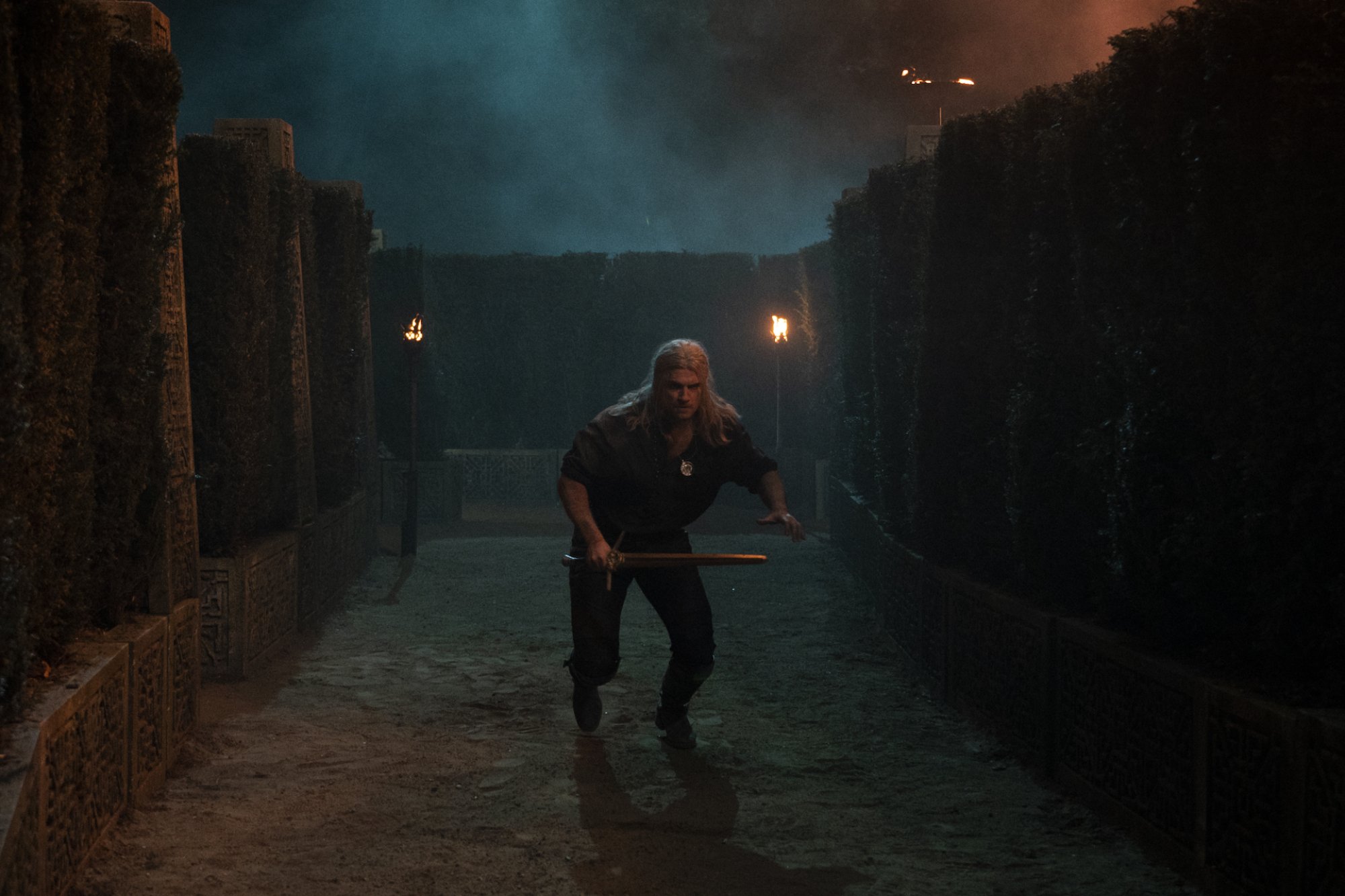 Henry Cavill como Geralt de Rivia, corriendo por un laberinto hacia 